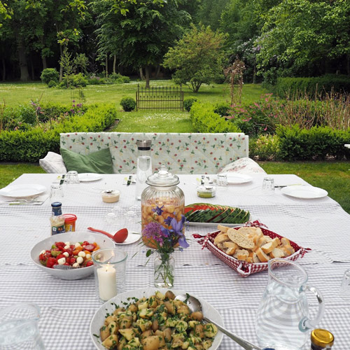 Gedeckter Tisch im Park. Sommer, Früchte und frischer Salat
